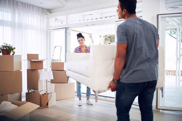 Shot of a young couple moving into their new place